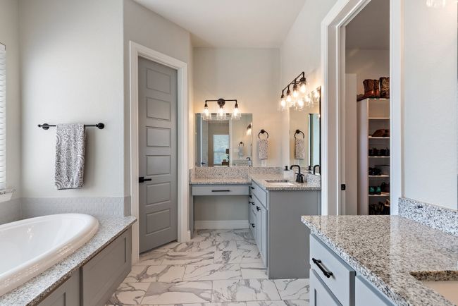 Bathroom with two vanities, a sink, a spacious closet, marble finish floor, and a garden tub | Image 17