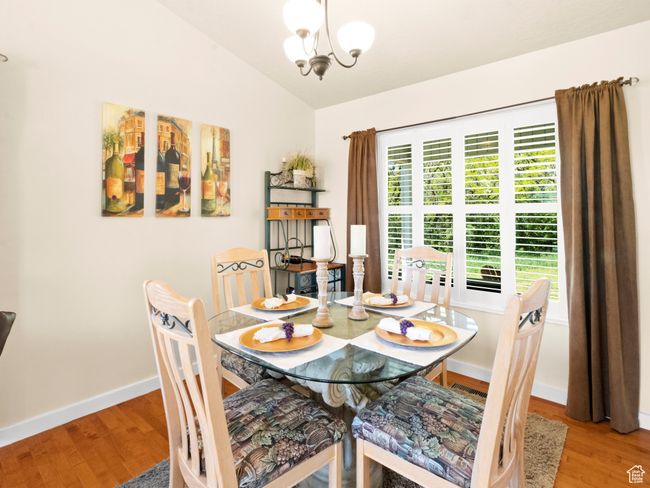 Dining room with wood finished floors and vaulted ceiling | Image 5