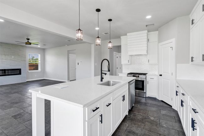 Kitchen featuring a sink, appliances with stainless steel finishes, recessed lighting, dark stone finish floors, and a ceiling fan | Image 16