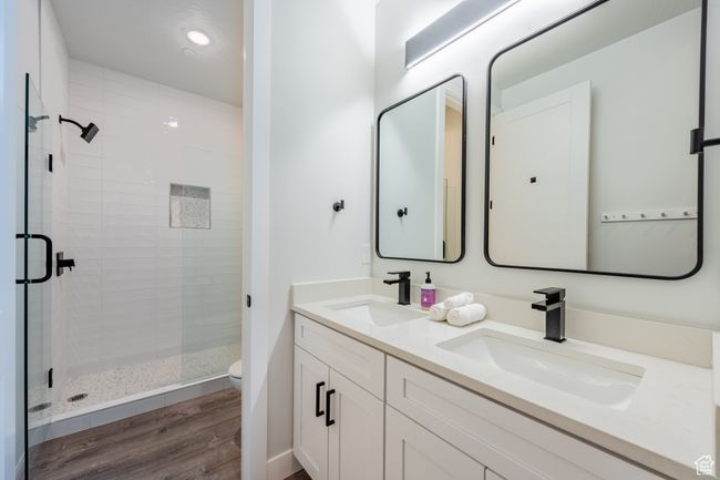 Bathroom with toilet, a shower with door, hardwood / wood-style flooring, and vanity | Image 39