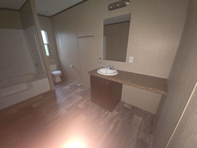 Full bath featuring toilet, shower / bath combination, wood finished floors, and vanity | Image 9