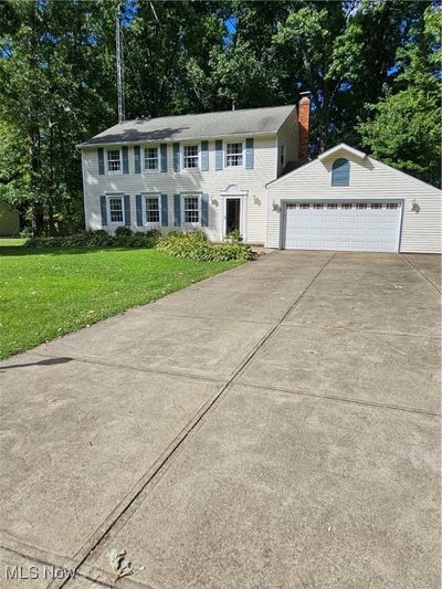 Colonial inspired home featuring a garage and a front lawn | Image 2