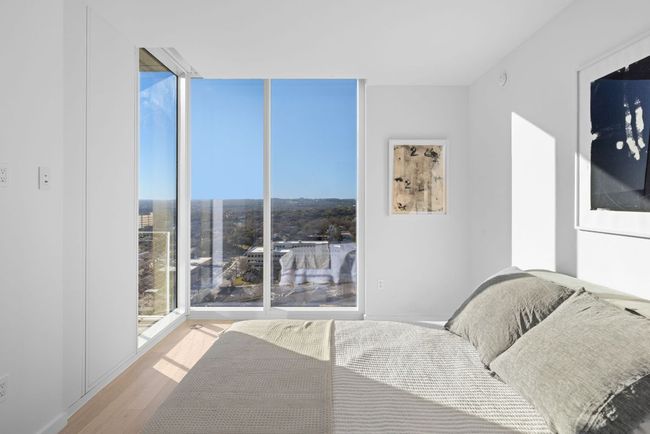 Bedroom featuring floor to ceiling windows and wood finished floors | Image 12