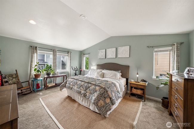 Primary bedroom has warm colors, vaulted ceilings & lots of natural lighting. | Image 16