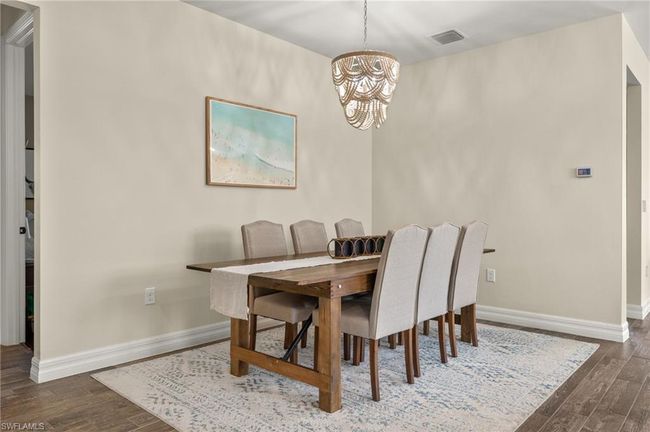 Dining area featuring a chandelier and dark hardwood / wood-style flooring | Image 7