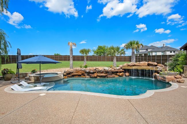 View of pool featuring a fenced backyard, a pool with connected hot tub, and a patio | Image 32