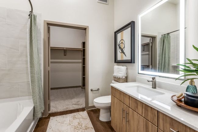 Full bathroom with vanity, hardwood / wood-style flooring, shower / bath combination with curtain, and toilet | Image 10