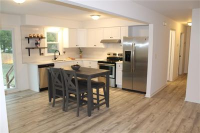 Kitchen with plenty of natural light, white cabinets, appliances with stainless steel finishes, and light wood-type flooring | Image 3