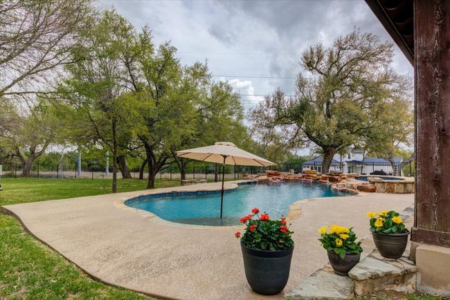 View of pool with a patio, a pool with connected hot tub | Image 35