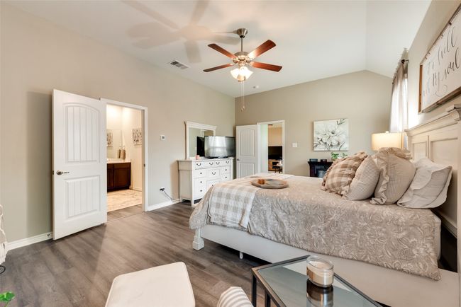 Bedroom featuring dark wood-style floors, ensuite bathroom, high vaulted ceiling, and a ceiling fan | Image 30