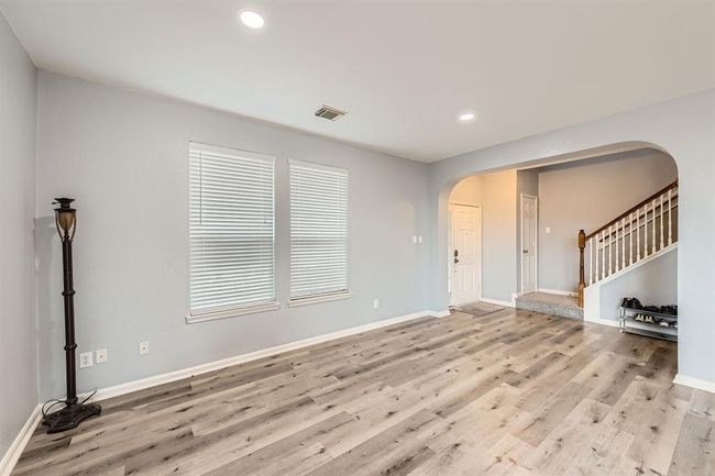 Welcoming entryway with modern flooring, tons of natural light, and a charming staircase, setting the tone for the rest of the home. | Image 10