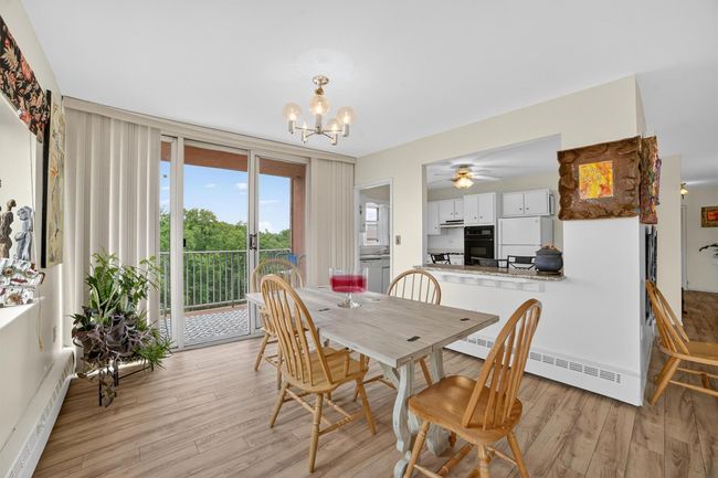 Dining space with baseboard heating, a chandelier, light wood-style flooring, and ceiling fan | Image 14