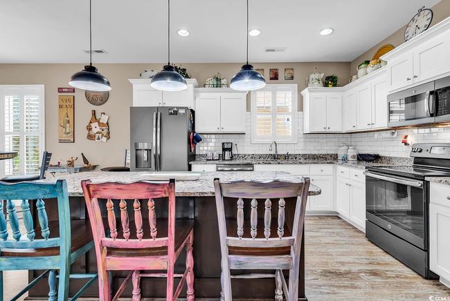 Kitchen with white cabinetry, visible vents, a sink, and stainless steel appliances | Image 10