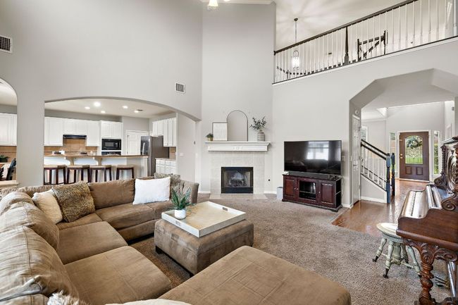 The living room is bright and open with fresh paint throughout, a gas fireplace, 2-story ceilings, and opens to the kitchen and breakfast nook. It also overlooks the beautiful backyard! | Image 14