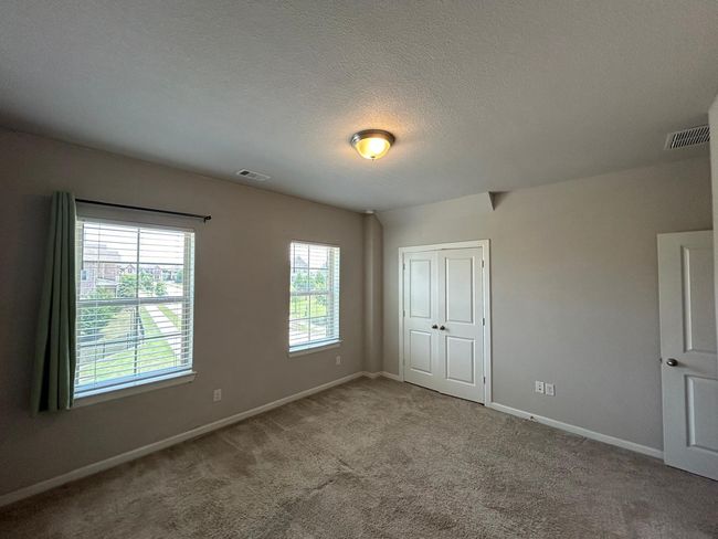 Unfurnished bedroom featuring baseboards, carpet, a closet, and a textured ceiling | Image 17