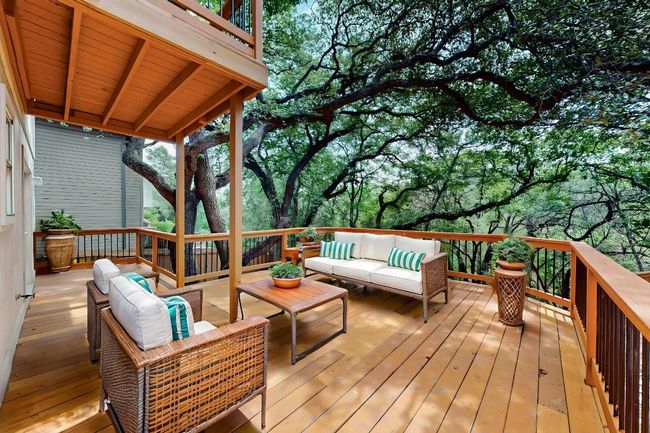 Wooden terrace with outdoor lounge area and view of scattered trees | Image 7