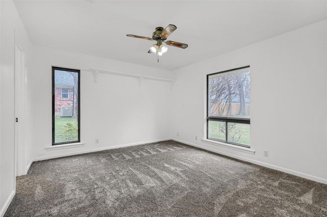 Carpeted empty room featuring a ceiling fan and baseboards | Image 18