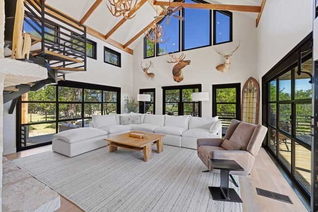 Living area featuring high vaulted ceiling, wood finished floors, a chandelier, and beamed ceiling | Image 19
