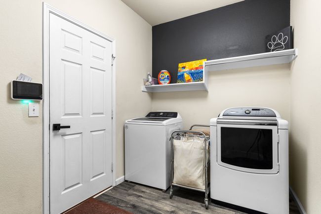 Laundry room featuring dark wood-type flooring and washer and clothes dryer | Image 17