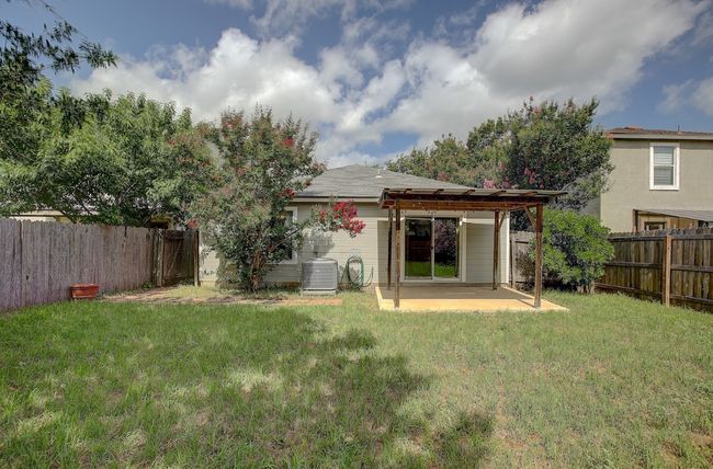Rear view of house with a patio area and central AC | Image 40