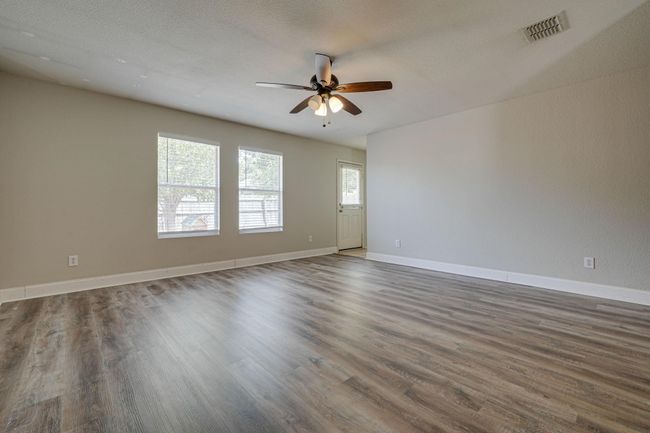 Spare room featuring a ceiling fan and dark wood-style floors | Image 11