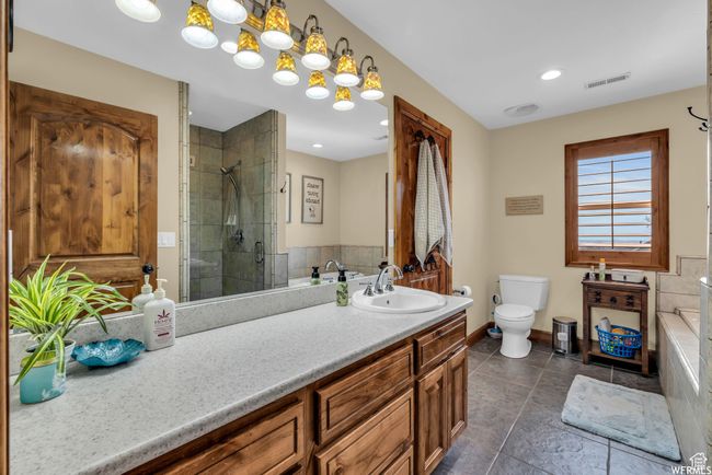 Bathroom featuring vanity, toilet, baseboards, a shower stall, and visible vents | Image 24