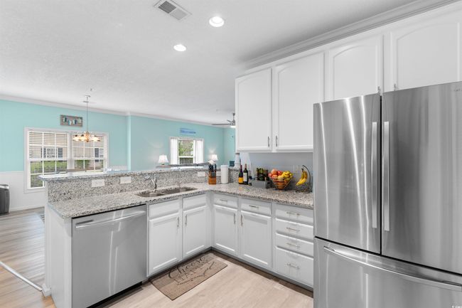 Kitchen featuring stainless steel appliances, a sink, a peninsula, light wood-style floors, and recessed lighting | Image 6