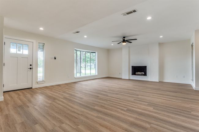 Unfurnished living room with a ceiling fan, light wood-style floors, recessed lighting, and baseboards | Image 8