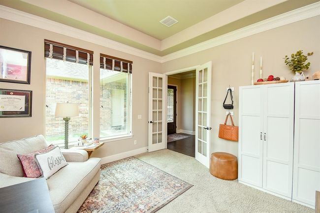 The library/study has French doors, tray ceiling and crown molding. Windows on 2 walls share views of spacious side yard large enough for pool. | Image 9