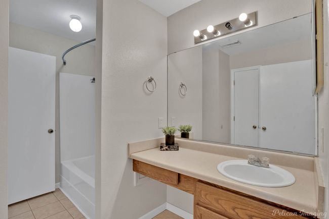 Bathroom featuring tile patterned floors, vanity, and shower / washtub combination | Image 19