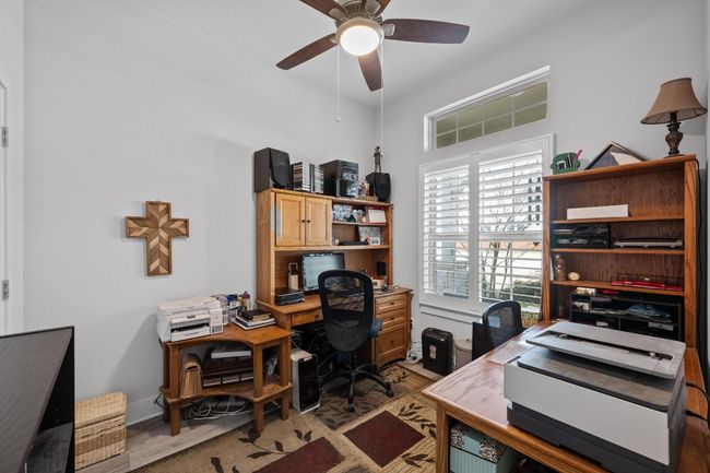 Office area with a ceiling fan and barn door. There is also a substantial closet in this closet/fourth bedroom. | Image 18