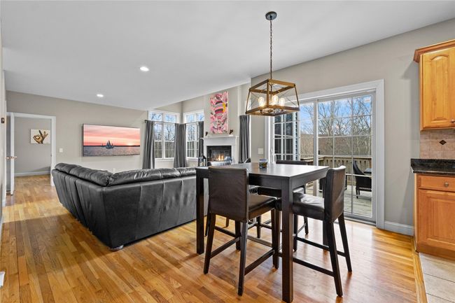 Dining room featuring light wood-type flooring, baseboards, a glass covered fireplace, and recessed lighting | Image 14