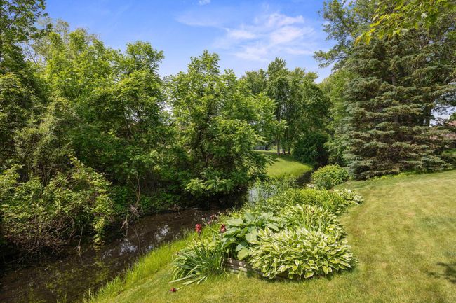 Beautifully landscaped includes your own serene creek. | Image 26