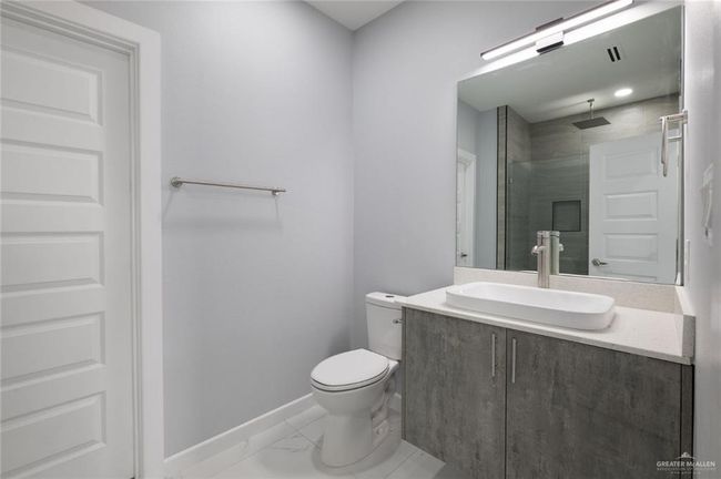 Bathroom featuring baseboards, vanity, toilet, marble finish floors, and a shower | Image 10