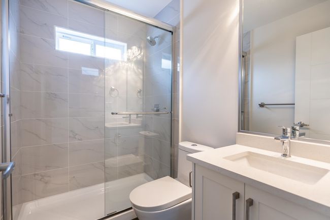 Bathroom featuring toilet, a stall shower, and vanity | Image 21