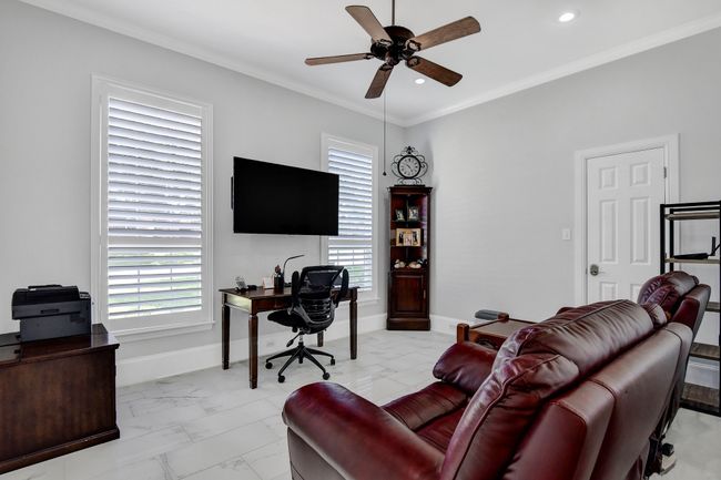 Living room with light marble finish floors, a desk, ceiling fan, healthy amount of natural light, and crown molding | Image 30