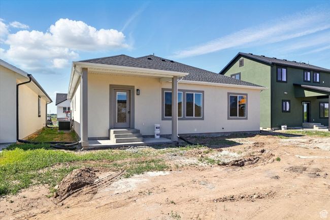 Back of house featuring cooling unit, stucco siding, and roof with shingles | Image 34