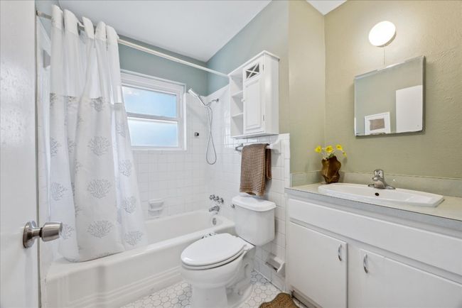 Full bathroom featuring vanity, tile patterned floors, shower / tub combo, and toilet | Image 22