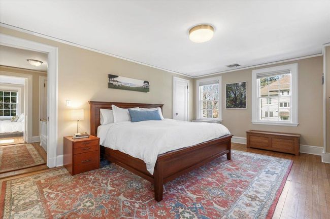 Bedroom with ornamental molding, wood-type flooring, visible vents, and baseboards | Image 14