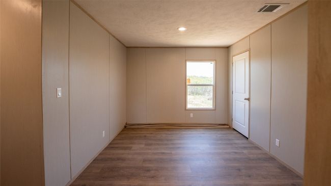 Unfurnished room with wood finished floors, a decorative wall, and recessed lighting | Image 20