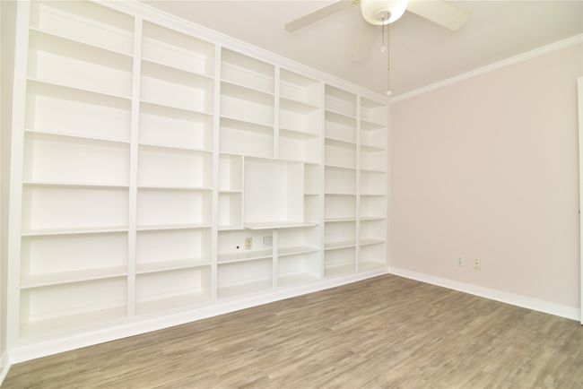 Spare room with wood finished floors, baseboards, a ceiling fan, and ornamental molding | Image 22