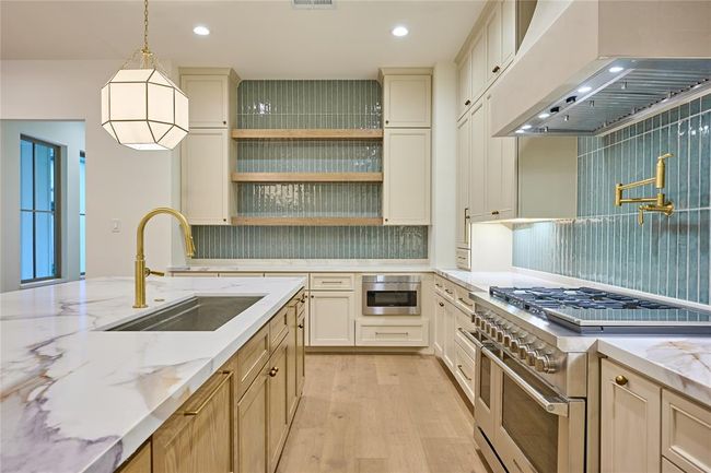 Two-toned cabinetry paired with subtle sage tone backsplash. | Image 17