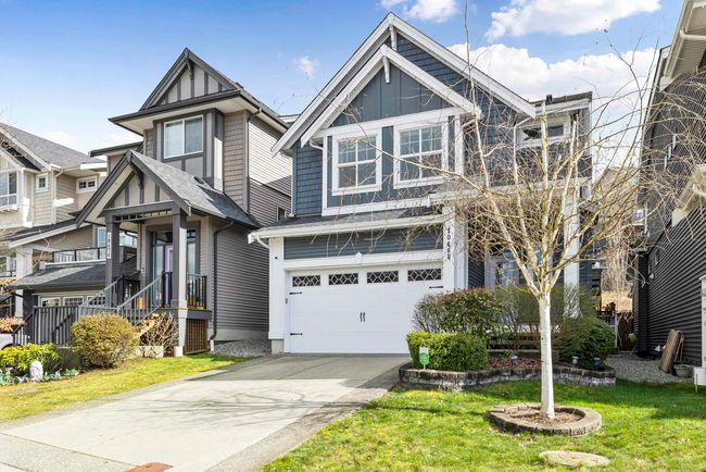 View of front of property featuring a front yard, an attached garage, board and batten siding, and driveway | Image 39