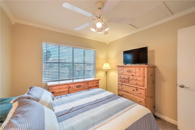 Bedroom featuring carpet flooring, crown molding, and ceiling fan | Image 11