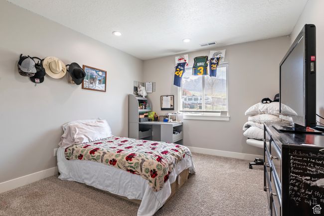 Bedroom featuring baseboards, visible vents, a textured ceiling, and carpet flooring | Image 26