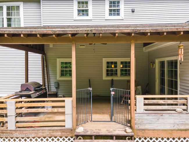 Rear view of house featuring a newer covered deck built in 2021 with sliding doors leading to breakfast nook | Image 44