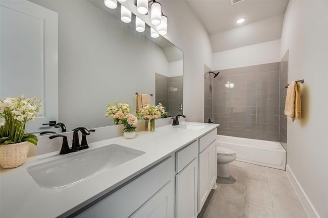 Bathroom with double vanity, tiled shower / bath combo, a sink, and toilet | Image 24