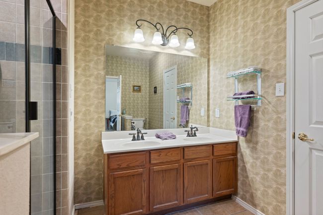 5' soaking tub and glass-enclosed shower with built-in storage ledge. | Image 26