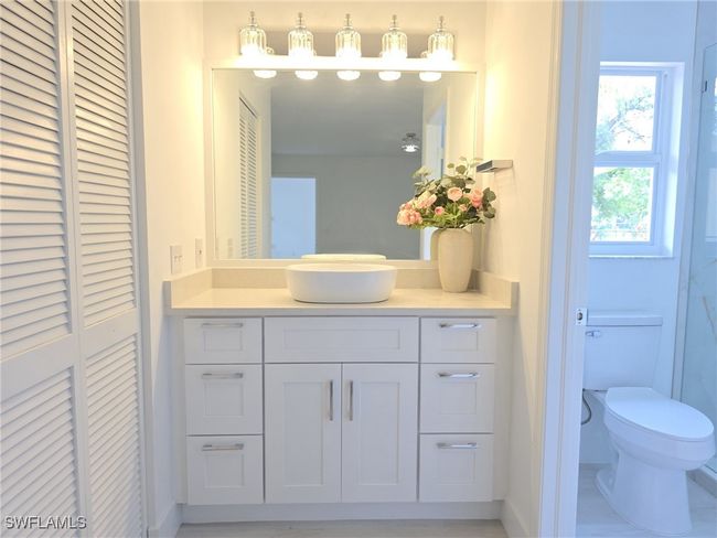 Bathroom featuring toilet, vanity, a closet, and baseboards | Image 21