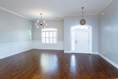 Foyer entrance with a notable chandelier, ornamental molding, and dark hardwood / wood-style floors | Image 2